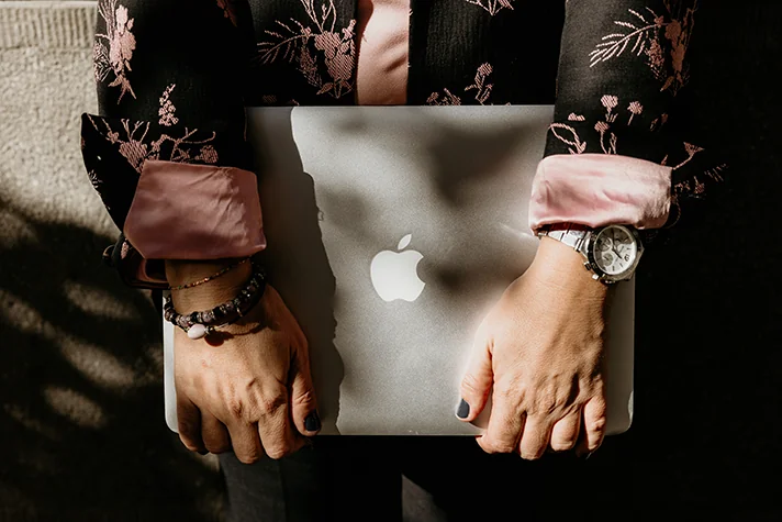 writer holding macbook pro
